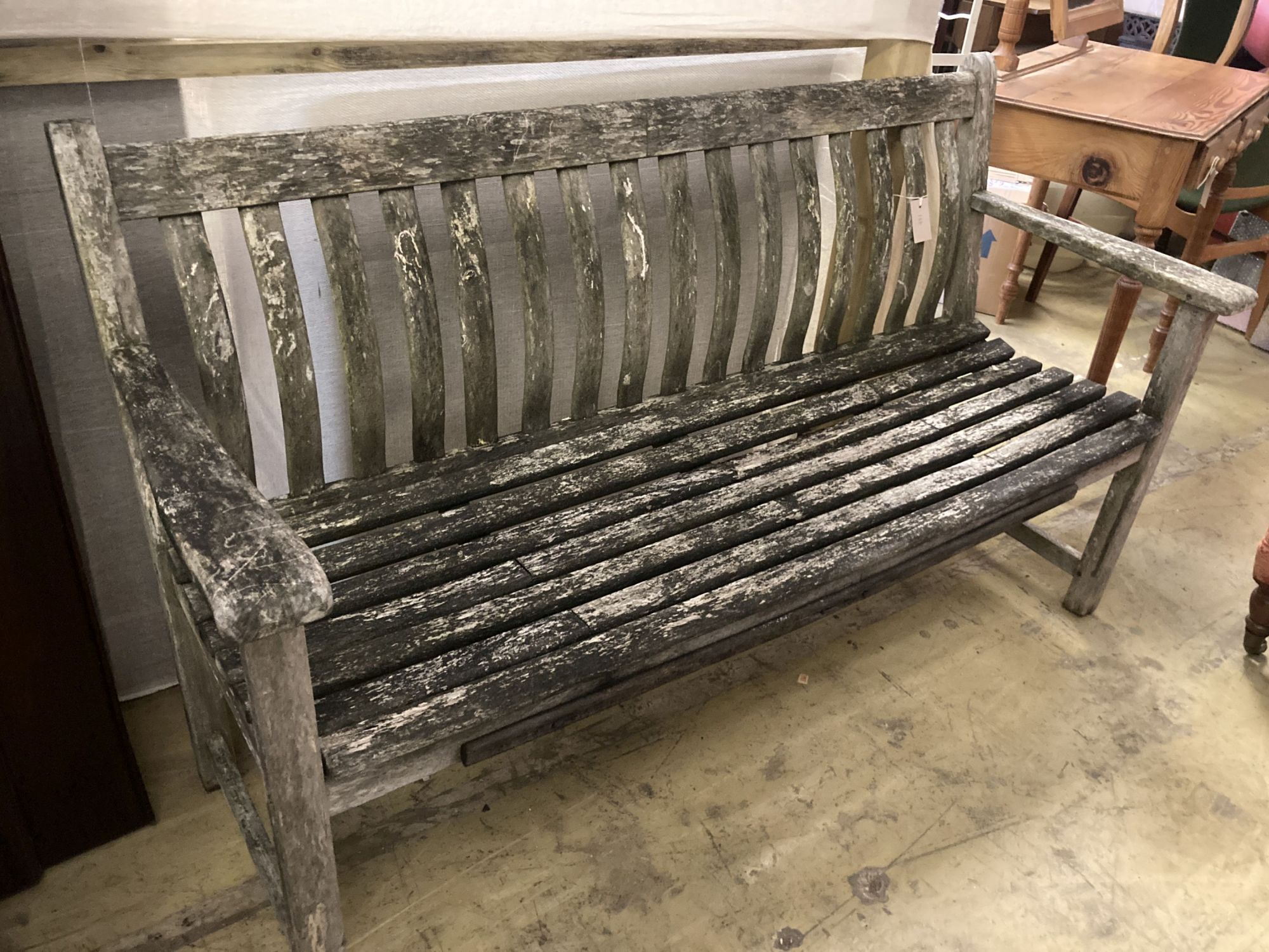 A weathered teak garden bench, length 150cm, depth 55cm, height 86cm